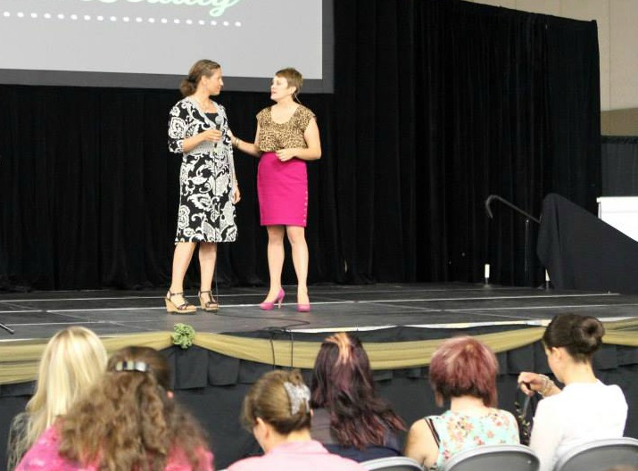 Amy speaking on stage at an event